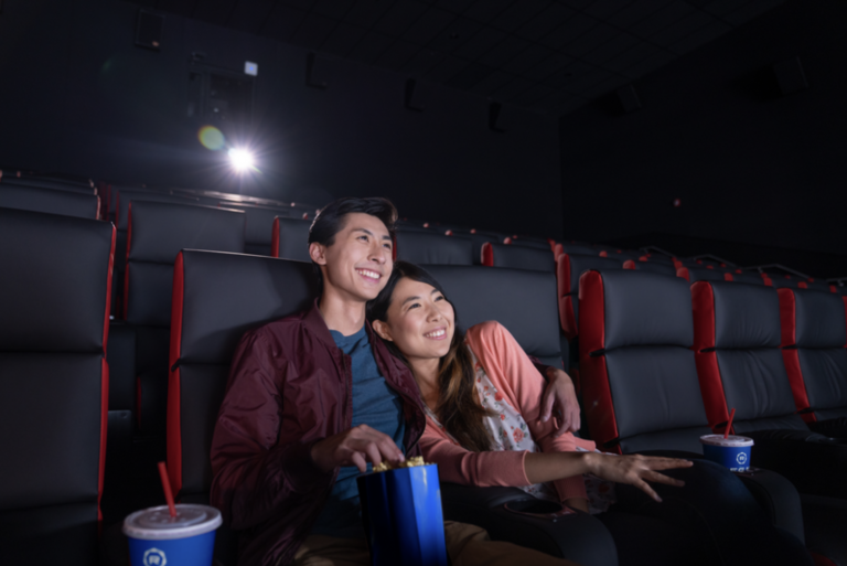 Young Asian couple watching movie in Regal Theater