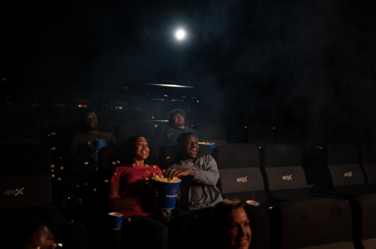 Young people sitting in Regal movie theater looking toward movie screen