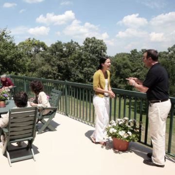 Loyola University Chicago - Event attendees socializing on outdoor balcony overlooking a scenic view.
