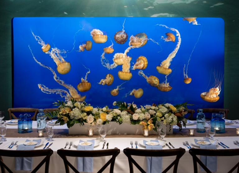 Vancouver Aquarium event tablescape with etherial jellyfish swimming in the tank behind it