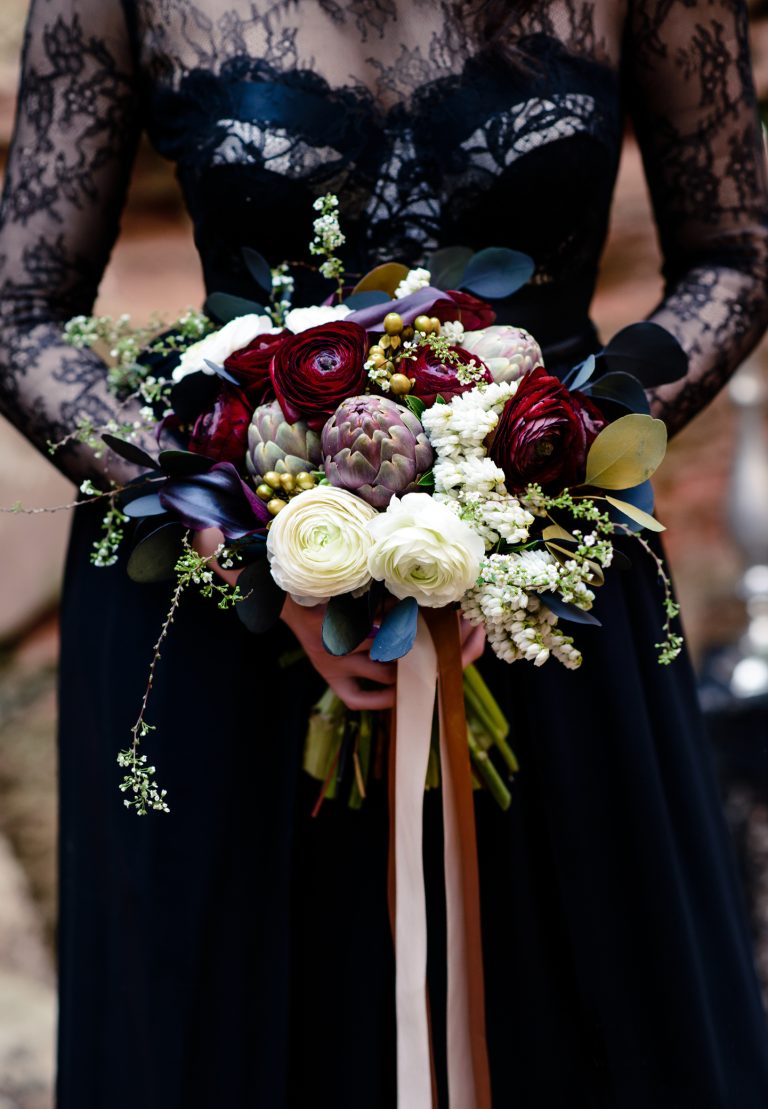 Bouquet in the hands of a girl in a black dress. Magic black, Gothic